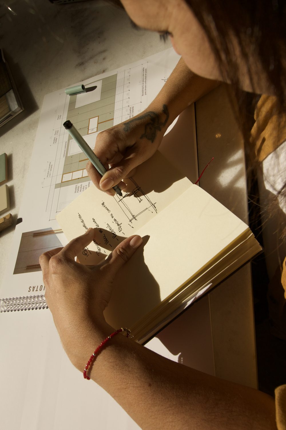Manos escribiendo en el cuaderno de obra